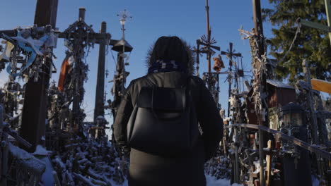 Pilgrim-woman-wearing-coats-walks-on-the-Hill-of-Crosses-in-Lithuania