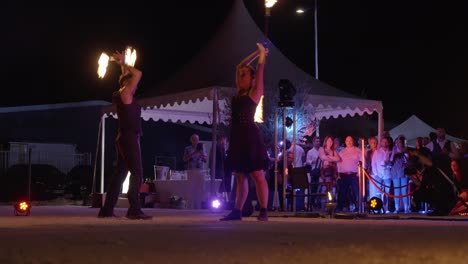 Professionelle-Straßenkünstler-Tanzen-Mit-Einem-Feuerstab-Und-Beobachten-Die-Menge-Auf-Der-Straße
