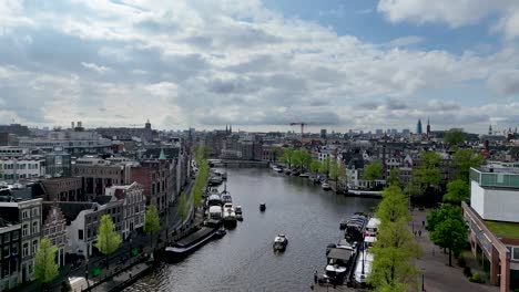Die-Drohne-Fliegt-Vorwärts-über-Den-Amstelkanal-Im-Stadtzentrum-Von-Amsterdam,-Niederlande,-Luftaufnahmen-4K