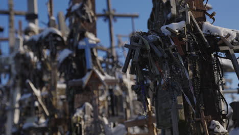 Ancient-religious-crosses-with-rosaries-at-a-Dutch-angle-under-a-blue-sky,-cinematic-shot-in-slow-motion