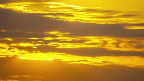 Golden-sky-sunset-between-moving-clouds,-time-lapse-relaxing-hopeful-transition
