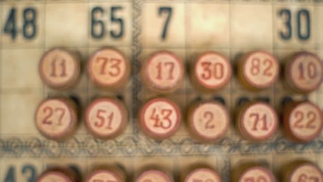 Cinematic-close-up-smooth-zoom-in-shot-of-a-Bingo-wooden-barrels,-woody-figures,-on-a-old-numbers-textured-background,-vintage-board-game,-lucky-number,-professional-lighting,-slow-motion-120-fps