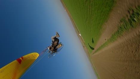 Vertical-format:-FPV-drone-buzzes-motor-paraglider-in-agri-countryside
