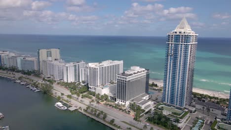 Epic-straight-drone-shot-of-Collins-Avenue-with-the-ocean-front-modern-condo-buildings-with-beautiful-water-view