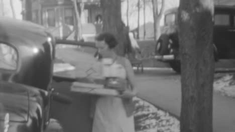Una-Mujer-Sale-De-Un-Automóvil-Clásico-Llevando-Cajas-De-Regalo-En-La-Ciudad-De-Nueva-York-En-La-Década-De-1930