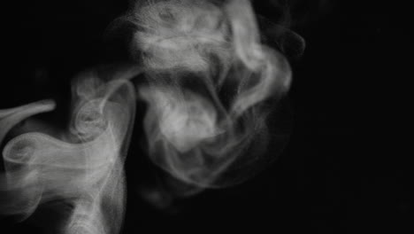 Macro-abstract-steam-particles-flowing-across-a-black-background-in-slow-motion