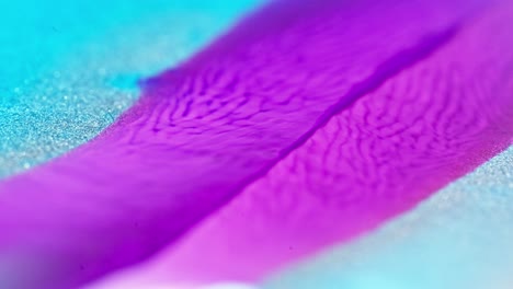 Die-Leuchtend-Violette-Tinte-Fließt-Ins-Blaue-Mit-Einem-Glitzernden-Frosteffekt-Und-ähnelt-Einem-Lebendigen-Fluss