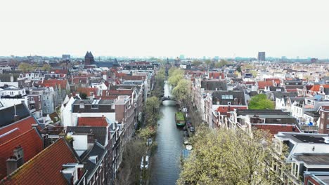 El-Dron-Vuela-Hacia-Adelante-Sobre-Un-Canal-En-Un-Día-Nublado-En-Amsterdam,-Países-Bajos,-Imágenes-Aéreas-4k
