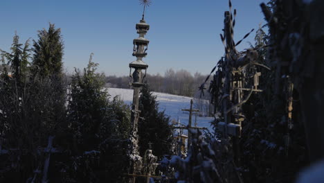Schöne-Alte-Katholische-Säule-Auf-Dem-Hügel-Der-Kreuze-In-Litauen-Zwischen-Schnee,-Bäumen-Und-Winter