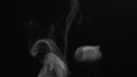 Close-up-steam-particles-swirling-and-rising-on-a-black-background-in-slow-motion