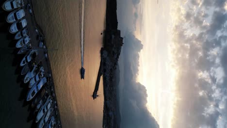 Die-Drohne-Fliegt-In-Einem-Zeitraffer-Vorwärts-über-Einen-Hafen,-Wo-Sie-Die-Boote-Segeln-Und-Die-Wolken-Auf-Ibiza,-Spanien,-Luftaufnahmen-In-4K-Sehen-Können