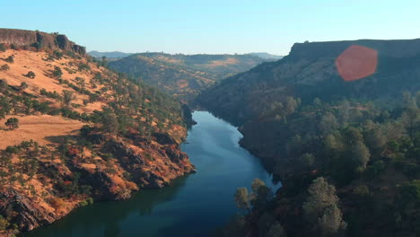 Aerial-flyover-of-a-beautiful-canyon-river-at-sunset-near-Lake-Tulloch-in-California