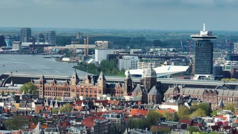 The-drone-is-flying-sideways-looking-at-central-station-with-a-telephoto-lens-in-Amsterdam-The-Netherlands-Aerial-Footage-4K