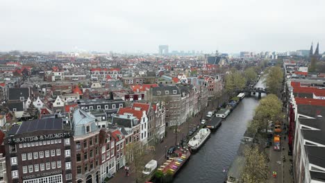 Die-Drohne-Fliegt-über-Die-Altstadt-Von-Amsterdam-über-Grachtenhäusern-In-Den-Niederlanden.-Luftaufnahmen-In-4K