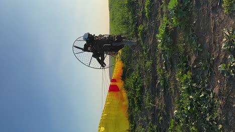 Vertical-format:-Paramotor-pilot-launches-canopy-into-clear-blue-sky