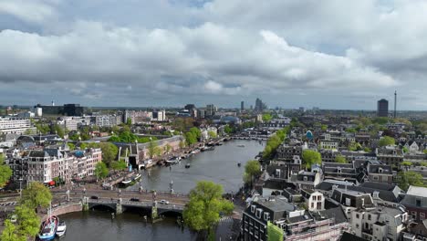 Die-Drohne-Fliegt-Seitwärts-Rotierend-über-Dem-Amstelkanal-Und-Bietet-Einen-Überblick-über-Die-Stadt-Amsterdam-In-Den-Niederlanden.-Luftaufnahmen-In-4K