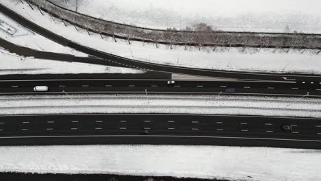 Highway-through-a-snowy-forest-landscape-seen-from-above