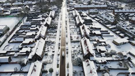 Beautiful-aerial-of-van-driving-through-a-beautiful-town-on-a-sunny-winter-day