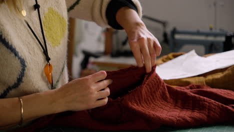 Seamstress-pinning-together-fabric-shirt-in-preparation-for-sewing-in-slow-fashion-design-studio