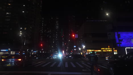 Point-of-view-shot-driving-on-the-night-lit-streets-of-Manhattan,-night-in-New-York