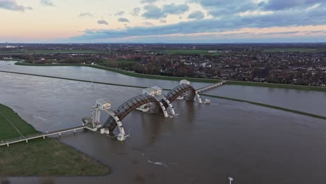 Flyover-drone-shot-towards-the-town-and-church-of-Driel-with-the-weir-of-Driel-in-the-forground-and-door-of-the-weir-open-during-high-waterlevels
