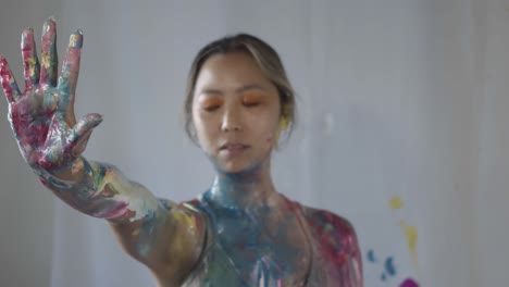Eine-Asiatische-Frau-Präsentiert-Ihren-Vollständig-Bemalten-Körper,-Der-Mit-Einem-Spektrum-Leuchtender-Farben-Geschmückt-Ist