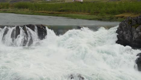 Wasser-Rauscht-über-Felsen-Und-Bildet-Stromschnellen-In-Der-Isländischen-Landschaft