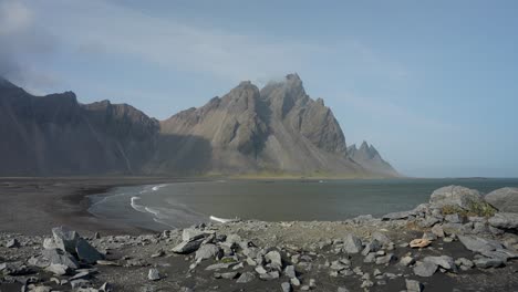 The-imposing-Vestrahorn-mountain-in-Iceland-forming-part-of-a-rocky-coastline