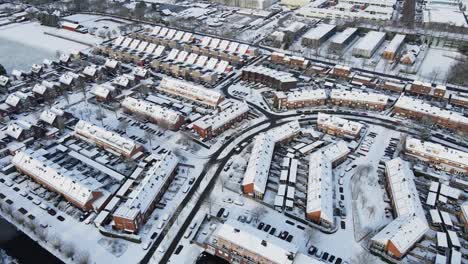 Beautiful-aerial-of-car-driving-trough-a-stunning-suburban-neighborhood-covered-with-snow