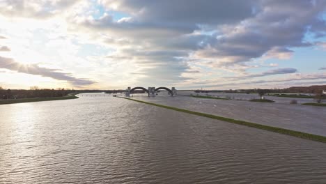 Approach-drone-shot-of-the-weir-of-Driel-during-high-water-levels-during-the-sunset