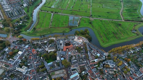 Die-Drohne-Fliegt-über-Den-Rand-Des-Stadtzentrums-Und-Die-Wiese-Von-Den-Bosch,-Niederlande,-Luftaufnahmen-4K