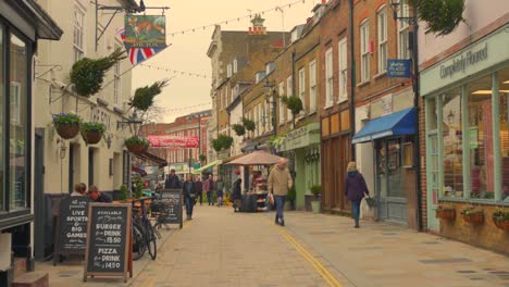 People-walking-on-shopping-street-in-Twickenham-district,-quaint-street-in-London,-England