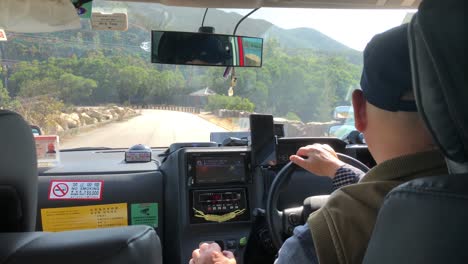 Taxista-Conduciendo-Por-Una-Carretera-Que-Conduce-Al-Embalse-De-High-Island-En-El-Parque-Rural-San-Kung-East,-Hong-Kong