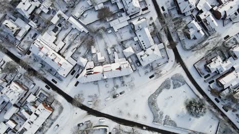 Top-down-aerial-of-a-snow-covered-suburban-neighborhood-with-clean-roads