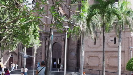 Camera-tilts-down-Basilica-bell-tower-to-plaza-in-Santa-Cruz,-Bolivia