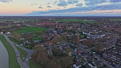 Flyover-drone-shot-away-from-the-town-and-church-of-Driel-over-the-weir-of-Driel-in-the-background-and-door-of-the-weir-open-during-high-waterlevels