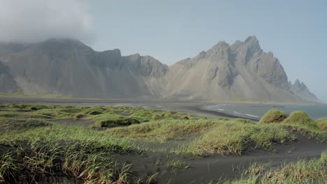 Ein-Windiger-Tag-An-Der-Isländischen-Küste-Mit-Einem-Ruhigen-Strand-Und-Dem-Majestätischen-Berg-Vestrahorn-In-Der-Ferne