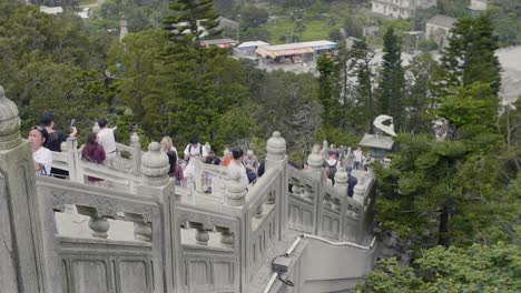 Tian-Tan-Buddha-staircase-filled-with-tourists-walking-up-and-down,-towards-and-away-from-the-statue---Super-Slow-Motion