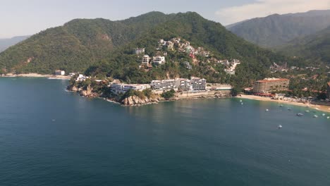 Aerial-pan-establishes-Mismaloya-village-with-boats-anchored-by-sandy-shore