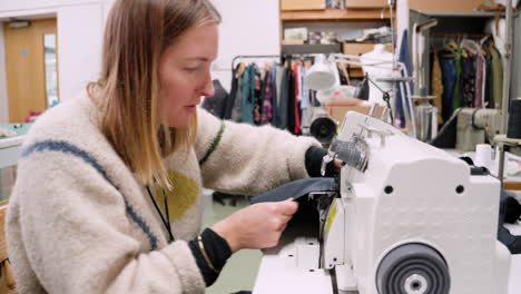 Seamstress-using-a-serger-overlock-machine-in-slow-fashion-textile-studio