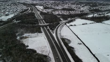M53-Motorway-snowscape-traffic-aerial-drone-hyperlapse-on-a-bitter-winter-morning---Wirral,-Merseyside,-UK