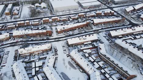 Aerial-of-beautiful-snow-covered-suburban-neighborhood-with-cars-driving-over-clean-road