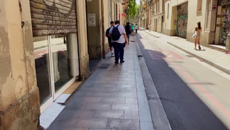Hombre-En-Mochila-Caminando-En-El-Callejón-Urbano-|-Barcelona,-España,-Ciudad-Inmersiva,-Paseo-Por-Calles-Concurridas-En-El-Barrio-Gótico,-Europa,-4k