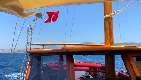 Girl-walking-and-talking-on-the-phone-on-a-big-boat-in-Bodrum-Turkey,-summer-vacation,-luxury-holiday-destination,-sunny-day-sea-view,-Turkish-flag,-4K-shot