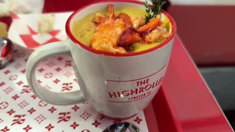 Close-Up-Shot-Of-Highroller-Mug-Filled-in-Maine-With-Warm-Lobster-Soup