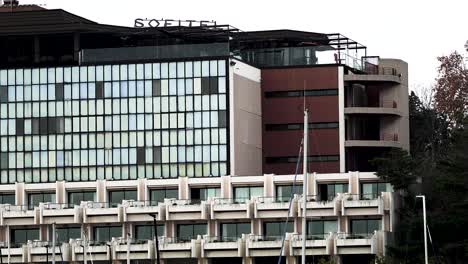 Exterior-of-the-Sofitel-Hotel-seen-from-the-port-from-a-floating-boat,-Long-shot