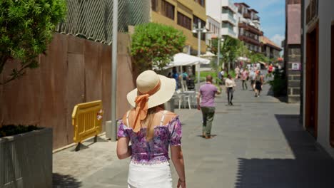 Female-tourist-sightseeing-old,-crowded-streets-of-Puerto-de-la-Cruz,-slowmo
