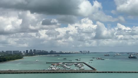 Blick-Auf-Am-Pier-Angedockte-Boote-Und-Fahrende-Boote,-Die-In-Der-Meerenge-Von-Singapur-Navigieren