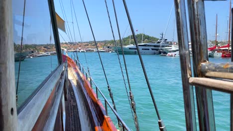 Bodrum-port-view-with-luxury-yachts-from-a-big-sailing-boat-in-Turkey,-summer-vacation,-moving-boat,-popular-holiday-destination,-sunny-sea-day-with-blue-sky,-4K-shot