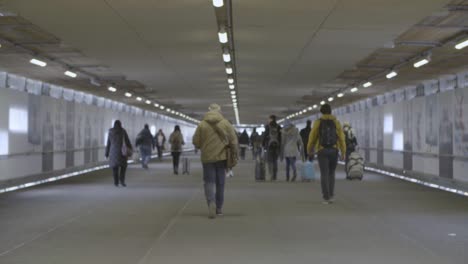 Viajeros-Caminando-Por-Un-Túnel-Peatonal-Urbano-Bien-Iluminado,-Día